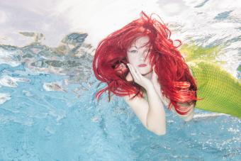 Red-haired mermaid swimming under water