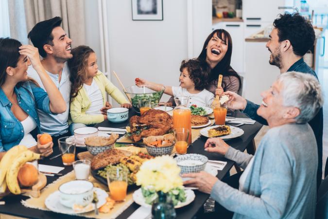 Family eating Thanksgiving dinner and laughing