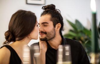 Pareja besándose durante la cena