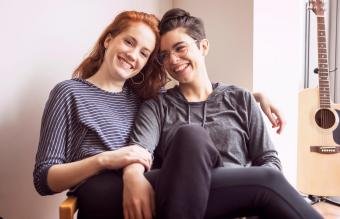 Pareja feliz sentada en una silla en casa