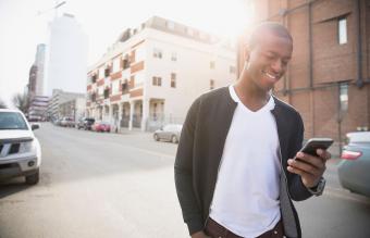 Hombre sonriente enviando mensajes de texto