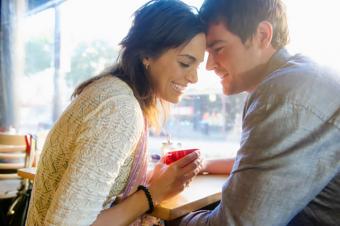 Pareja tomada de la mano en un café