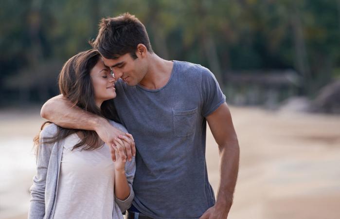 Pareja joven caminando por la playa