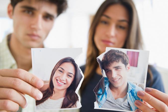 Pareja sosteniendo fotografía rasgada tras una ruptura