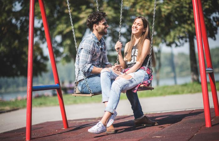 Pareja joven en columpios