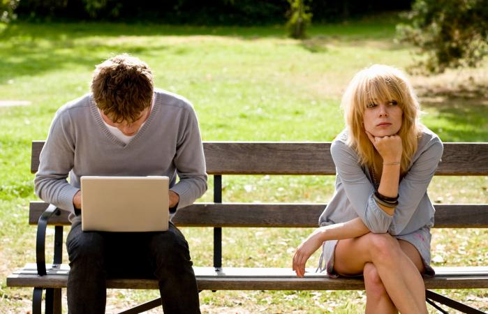 Hombre en la computadora y mujer infeliz