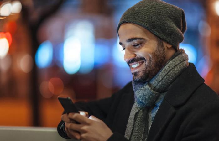 Chico joven usa su teléfono móvil