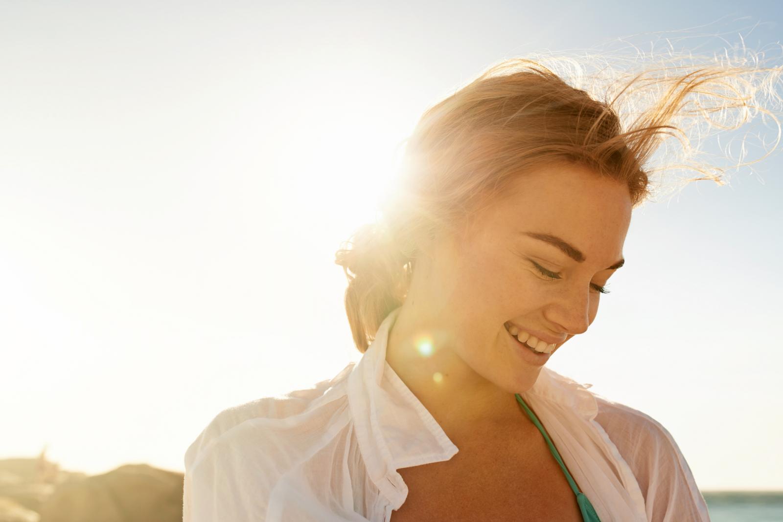 Mujer en la playa sonriendo