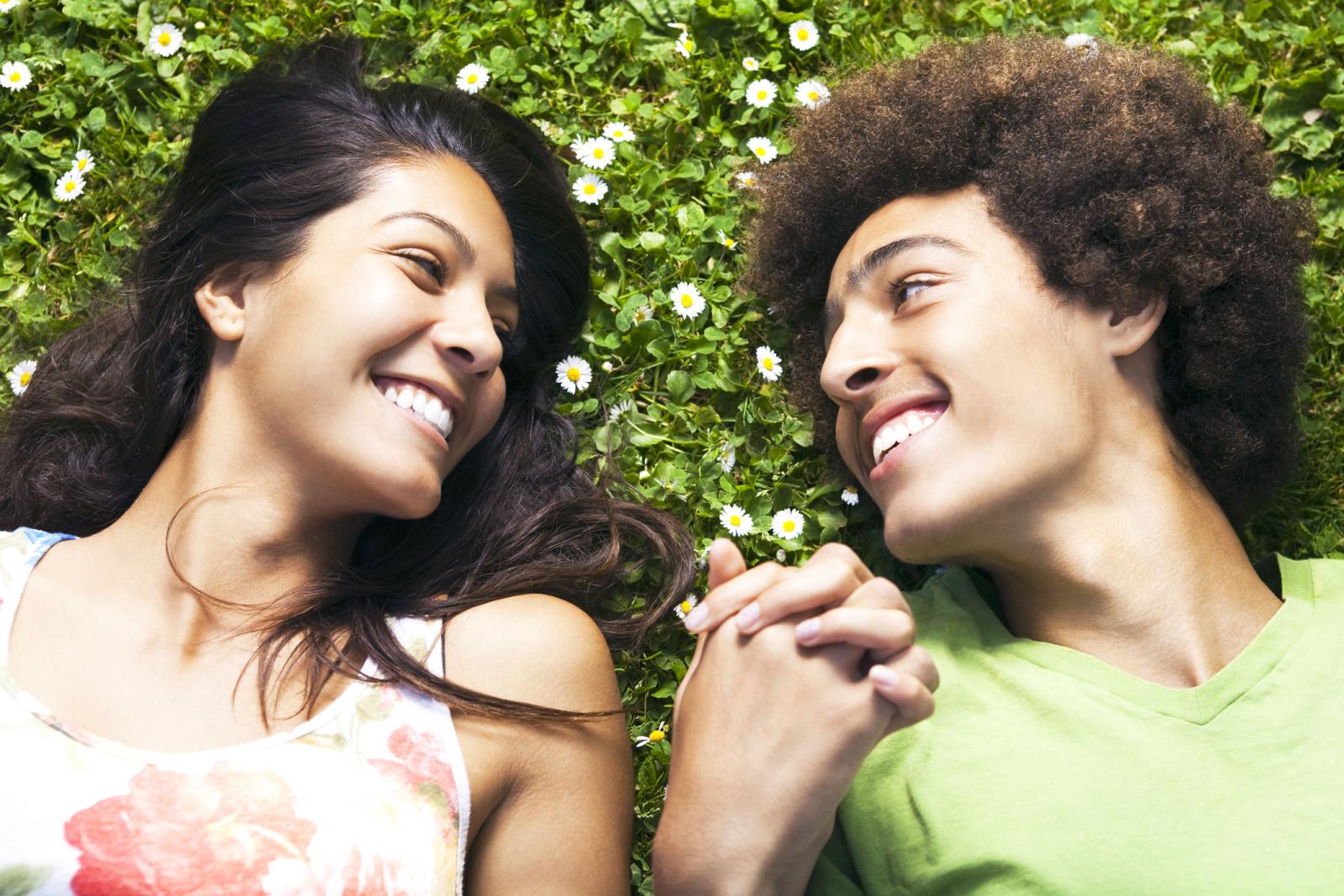 Pareja enamorada tumbada en el cesped