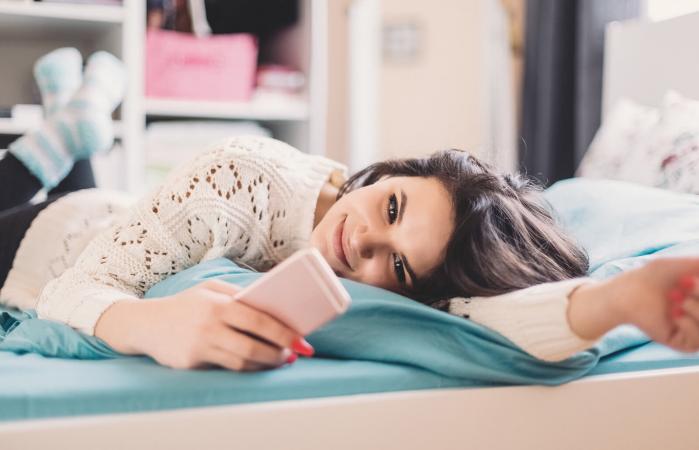 Chica adolescente usando teléfono móvil