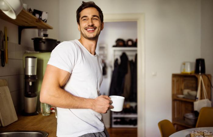 Joven en la cocina con café