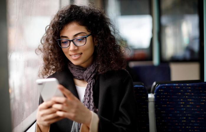 Mujer joven sonriente usando un celular