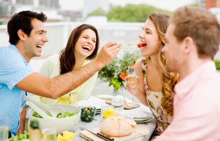dos parejas almorzando sonriendo