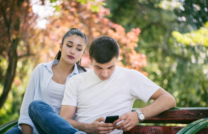 Chica espiando teléfono de su novio