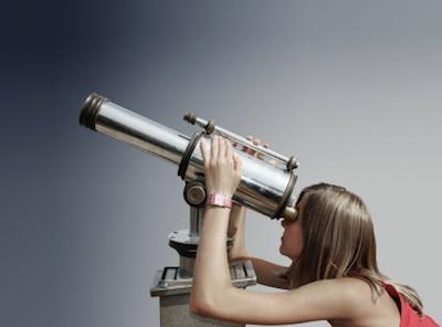 Woman looking through a telescope