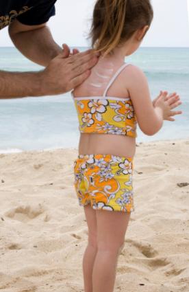Applying sunscreen to a child's back