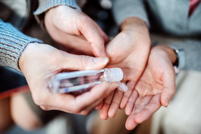 Squeezing hand sanitizer in cupped hands