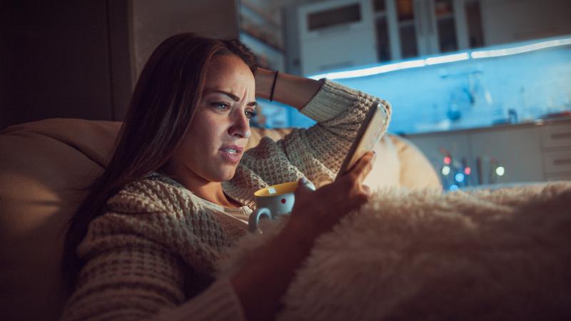 Woman looking worried while reading phone