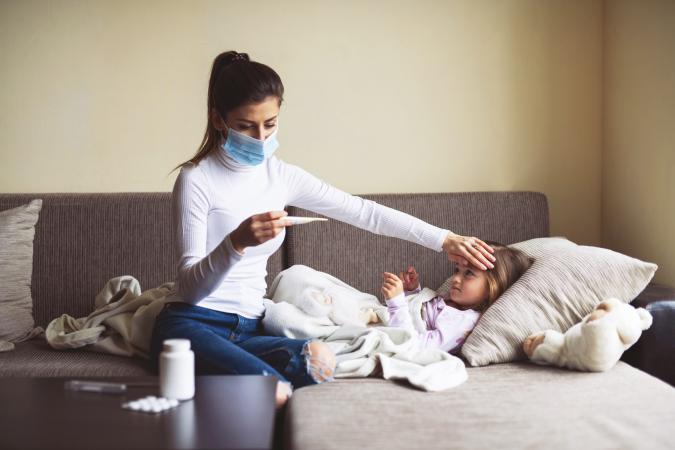 A Mother Measure Temperature On Her Sick Child At Home