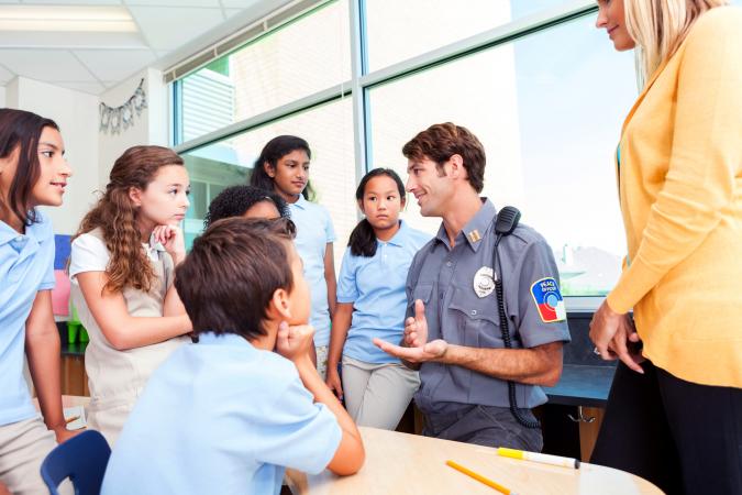 Children interested in what a police officer has to say about safety in their school