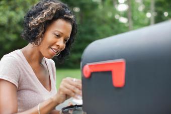 Woman taking mail from mailbox