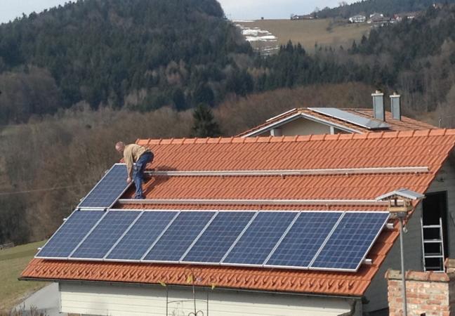 Worker Installing Solar Panels on Roof