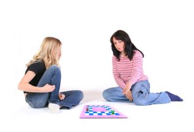 Two teen girls playing a board game