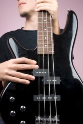 Young man holding an electric bass guitar