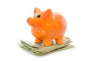 Piggy bank standing on a stack of money