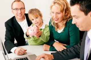 Family with advisor around computer; girl with piggy bank