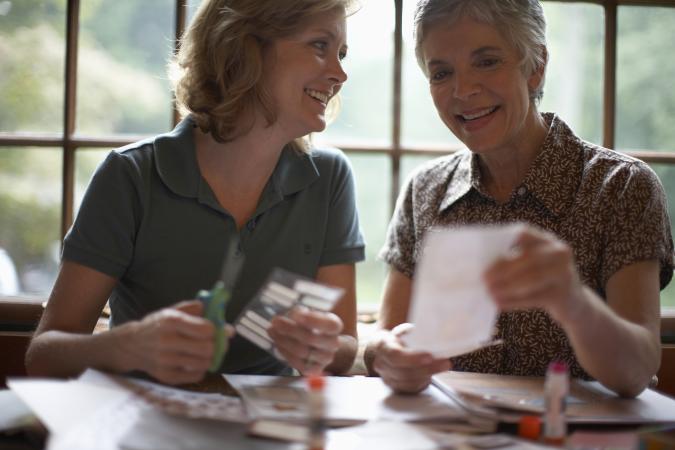 Two women assembling scrapbook