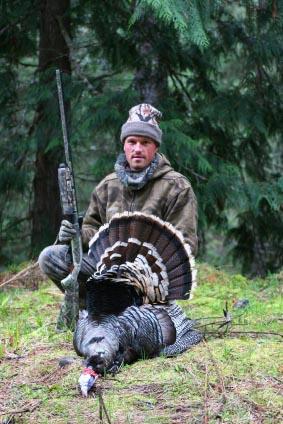 Hunter posing with wild turkey