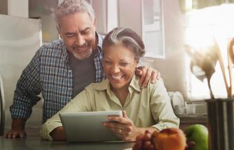 Senior couple using tablet and laughing