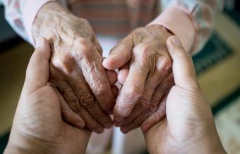 Young woman holding elder hands