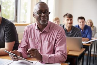 older man learning in classroom