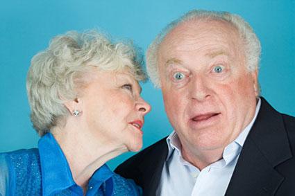Senior woman whispering to husband