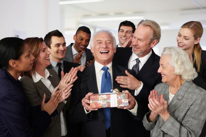 Colleagues giving retirement gift to businessman