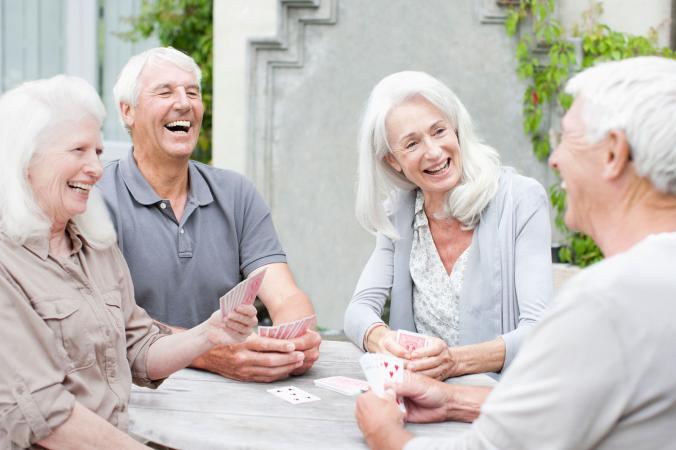 Seniors playing cards on outdoor patio
