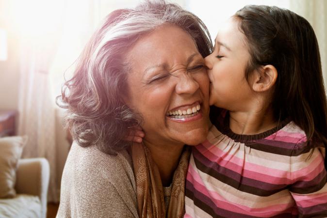 Granddaughter kissing her grandmother's cheek