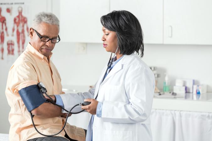 Doctor taking man's blood pressure