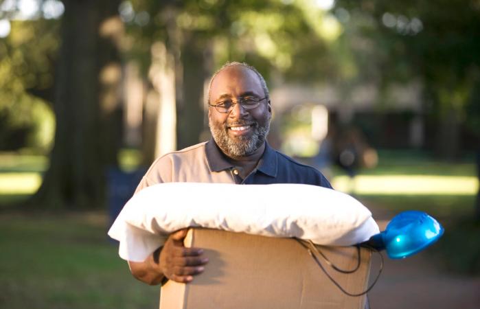 Smiling man carrying box