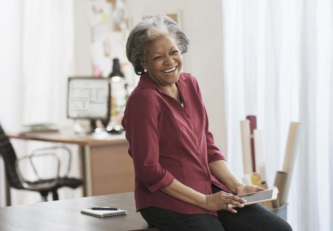 Senior woman laughing at tablet