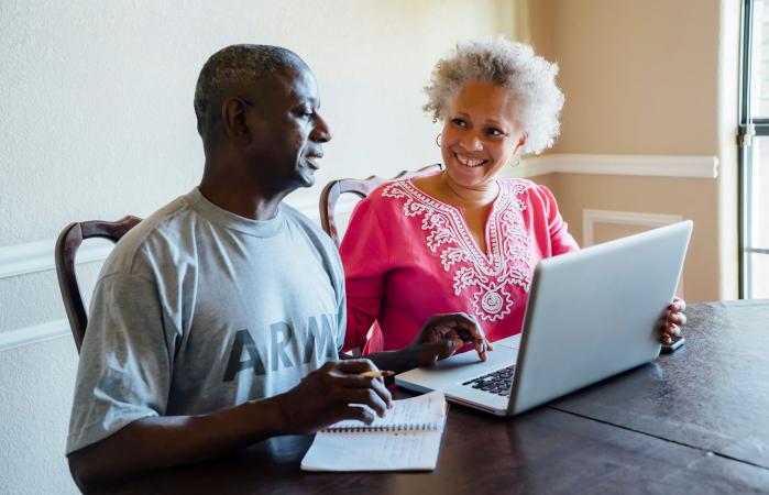 Senior couple using laptop at table