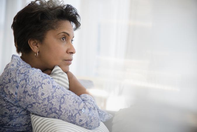 Woman clutching pillow looking pensive