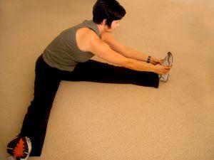 Woman sitting on floor and stretching