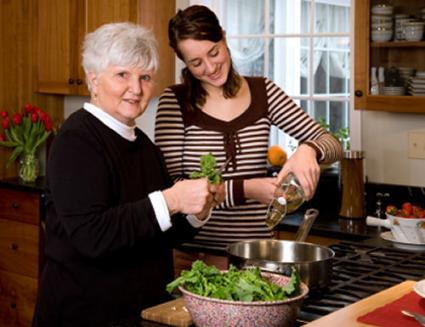 Senior woman and daughter making salad together