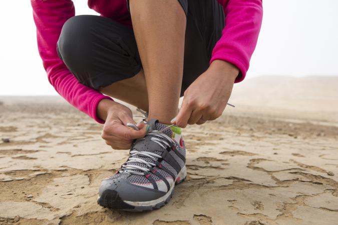 woman tying tennis shoe