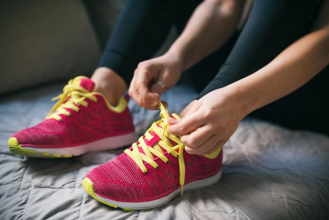 Woman putting on running pink shoes