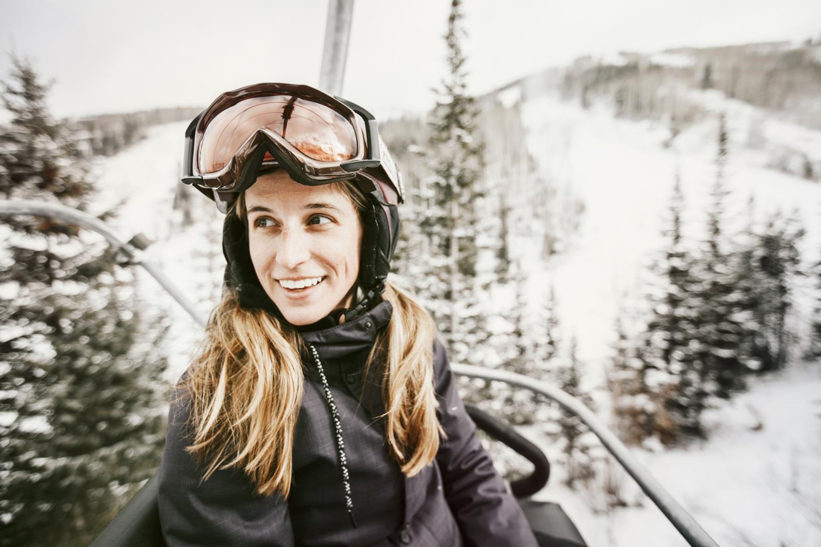 Smiling woman riding ski lift