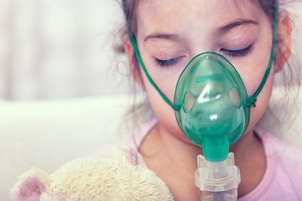 Young girl wearing an oxygen mask